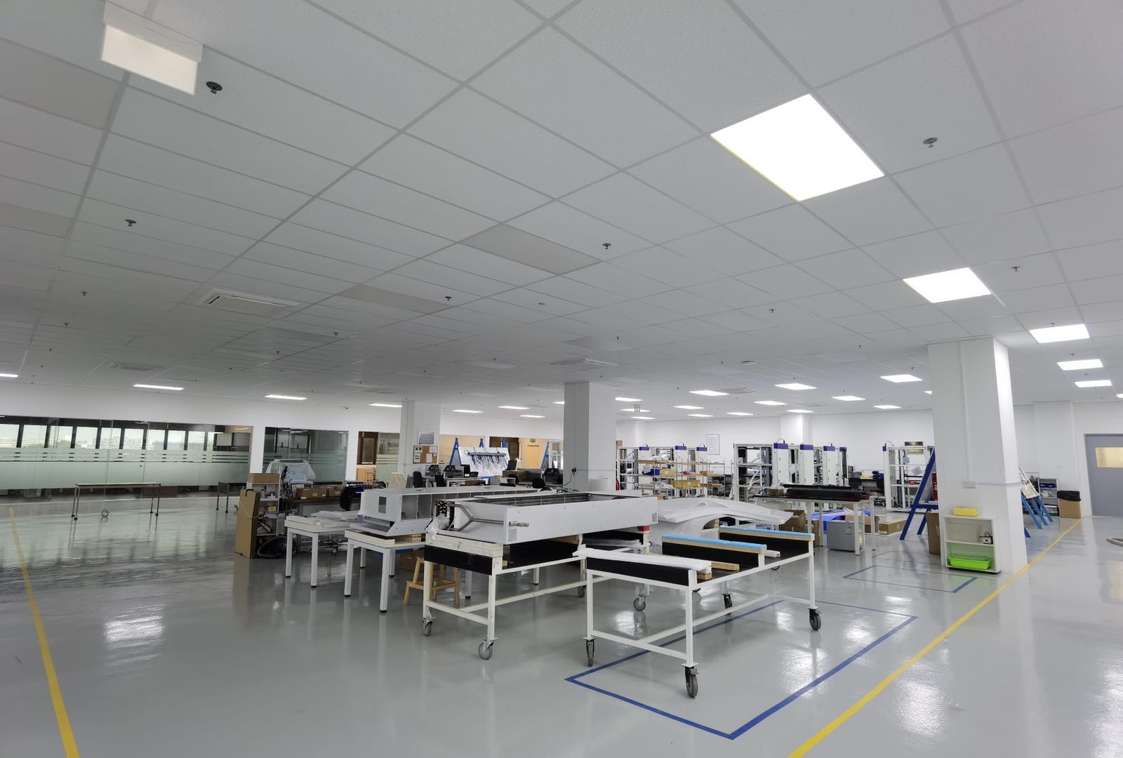 Open workshop floor with assembly benches in a commercial office and warehouse fit-out